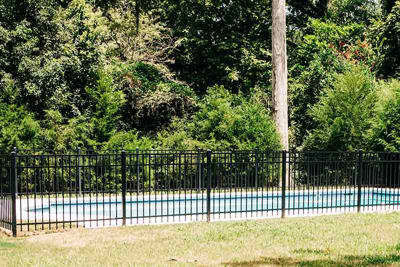 inground swimming pool surrounded by fencing