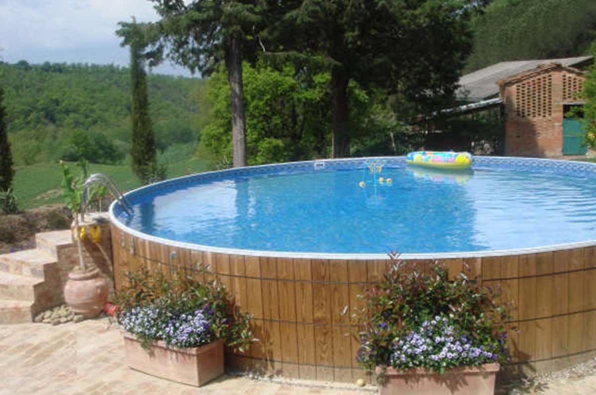 wooden round above ground pool with stairs outside the pool and SS ladder