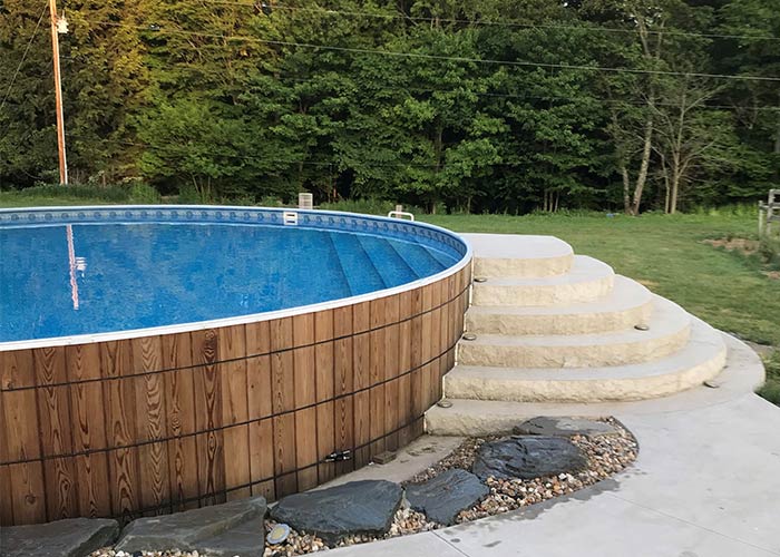 wooden round above ground pool with walk-in stairs and outside stairs